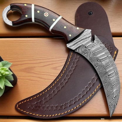 Decorative knife with a wooden handle and Damascus steel blade on a wooden surface.